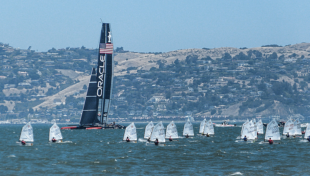 Oracle USA cat sailing through a fleet of optis